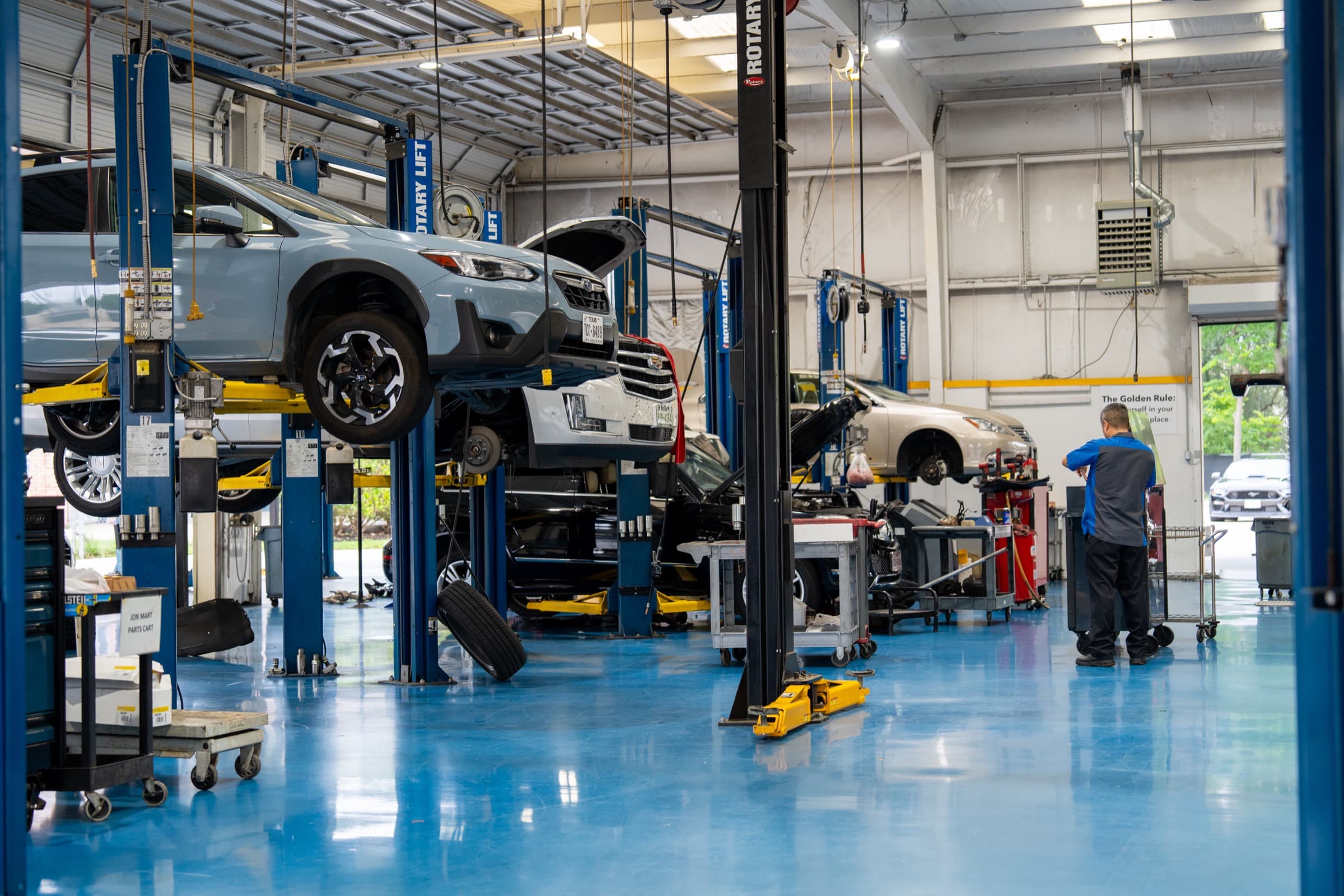 An operating repair shop floor with vehicles on lifts