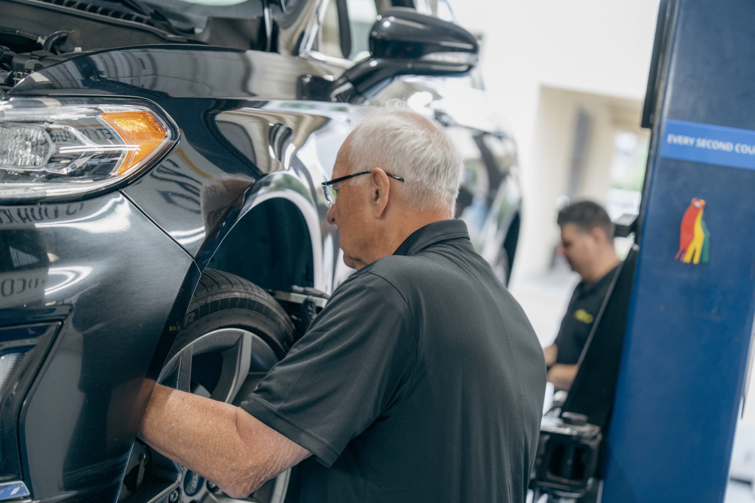 A technician walking through a vehicle inspection on the shop floor
